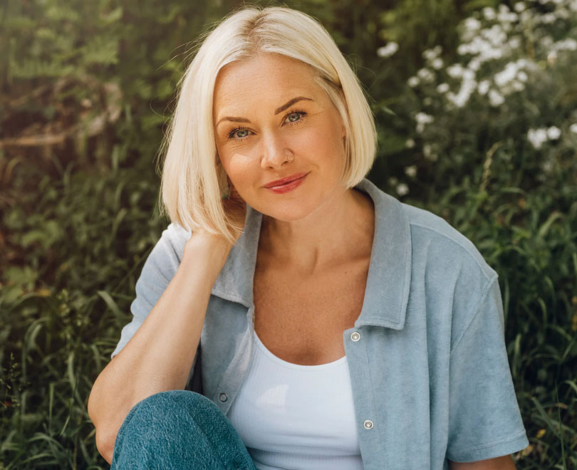 Image of an older blonde woman with short hair looking straight at the camera