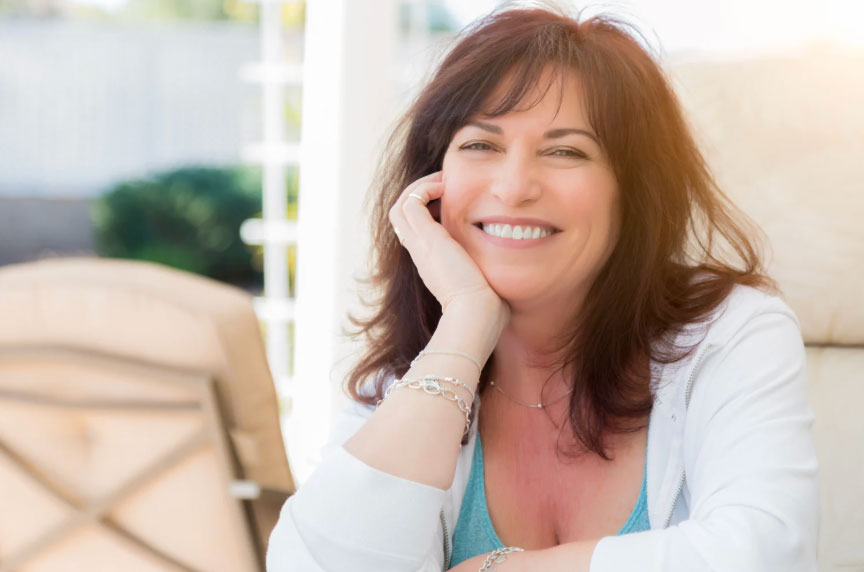 Image of a pretty older brunette woman with long hair and a big smile